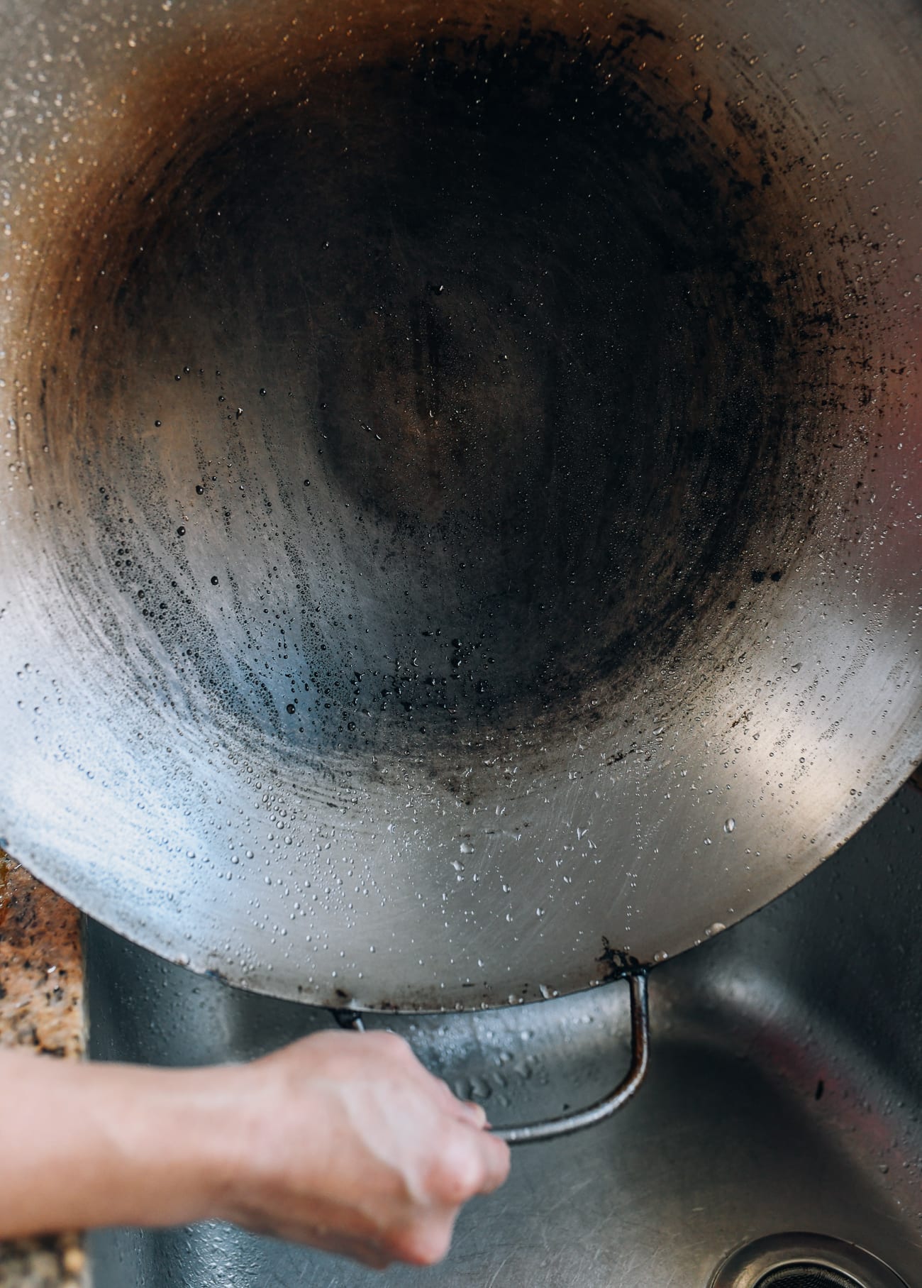 How to Wash a Wok - holding up a clean wok over the sink
